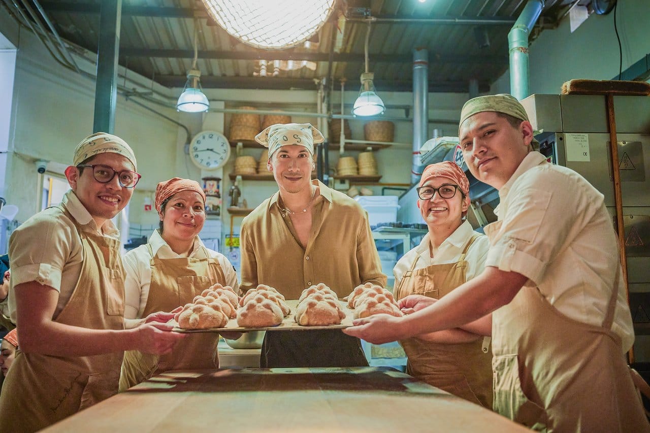 Cultural ambassador and longtime Tequila Don Julio partner Carlos Eric Lopez with the baking staff at Panadería Rosetta with fresh pan de muerto. Photo credit: The Maestros
